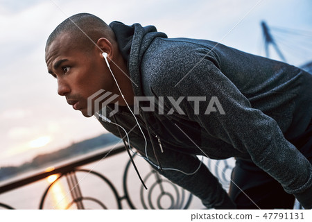 Tired because of running. Young jogger is stopped to catch his breath Tired because of running. Young jogger is stopped to catch his breath 47791131