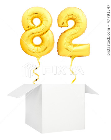 Golden number eighty two inflatable balloon with golden ribbon flying out of blank white box 47791347