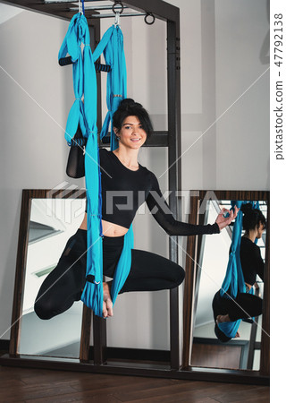 Yoga in a white room. woman performs physical exercises fly-yoga, pilates on a special equipment 47792138