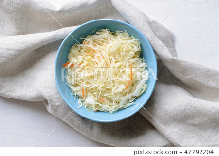 Blue bowl with sauerkraut on a white table Blue bowl with sauerkraut on a white table 47792204