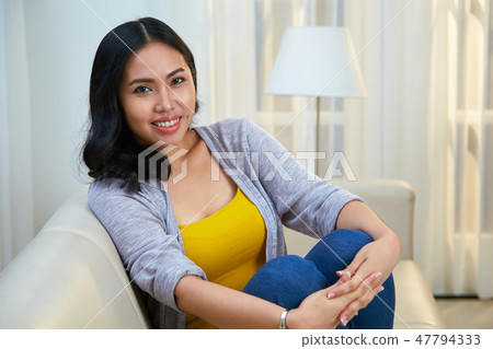 Lovely woman sitting on sofa 47794333