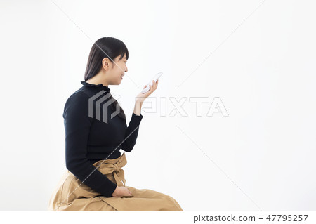 Young lady speaking to a smartphone Voice input Young lady speaking to a smartphone Voice input 47795257