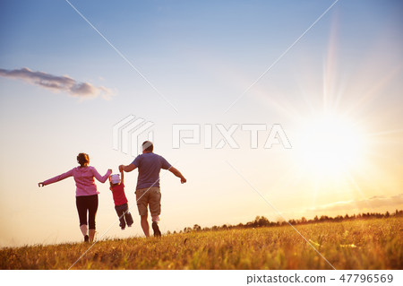 girl with mother and father holding hands on the nature girl with mother and father holding hands on the nature 47796569