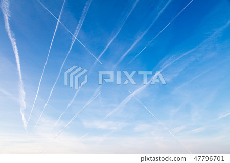 Traces of white smoke from an airplane on a blue sky Traces of white smoke from an airplane on a blue sky 47796701