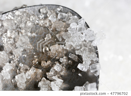 White granulated sugar on a metal spoon White granulated sugar on a metal spoon 47796702
