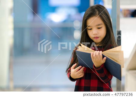 child holding open textbook in hands in book stor 47797236