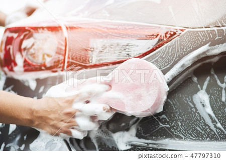 The man hand with pink sponge clean washing car  47797310