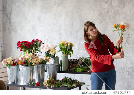 Florist workplace. Woman arranging a bouquet with roses, chrysanthemum, carnation and other flowers 47801774