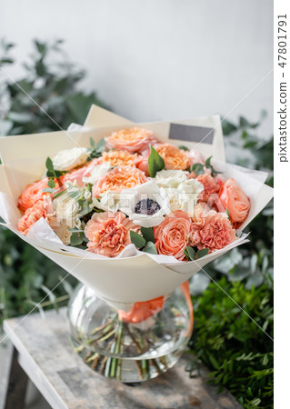 beautiful fresh cut bouquet of mixed flowers in vase on wooden table. The work of the florist at a beautiful fresh cut bouquet of mixed flowers in vase on wooden table. The work of the florist at a 47801791