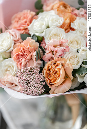 beautiful fresh cut bouquet of mixed flowers in vase on wooden table. The work of the florist at a 47801813
