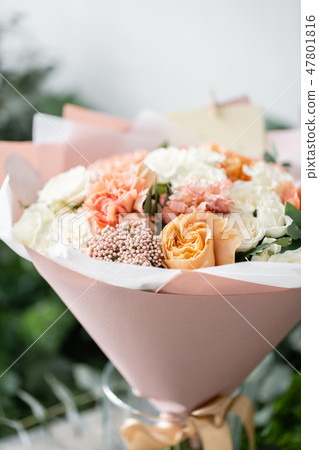 beautiful fresh cut bouquet of mixed flowers in vase on wooden table. The work of the florist at a 47801816