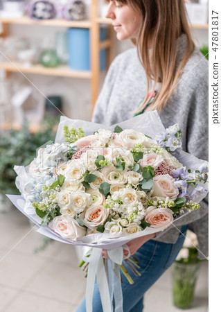 beautiful fresh cut bouquet of mixed flowers in woman hand. the work of the florist at a flower shop 47801817