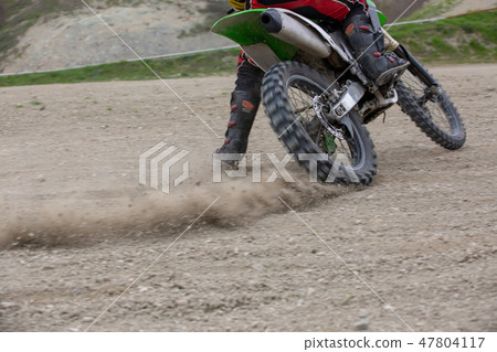 Professional Motocross Motorcycle Rider Drives Over the Road Track. Professional Motocross Motorcycle Rider Drives Over the Road Track. 47804117