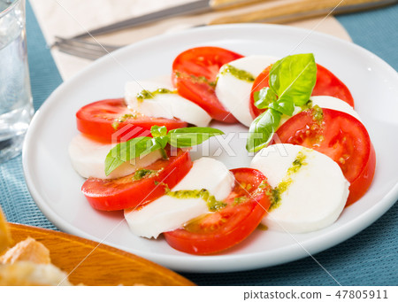 Plate of salad with cheese and tomatoes 47805911