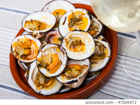 Baked in oven with sauce open seashell served at white plate 47806972