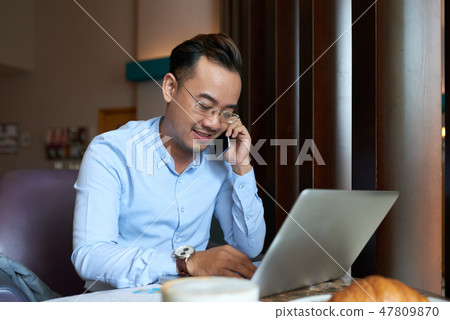 Asian businessman talking on phone Asian businessman talking on phone 47809870
