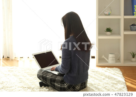 A woman who plays a personal computer 47823129