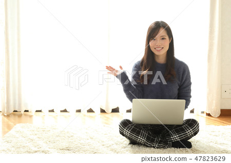 A woman who plays a personal computer 47823629