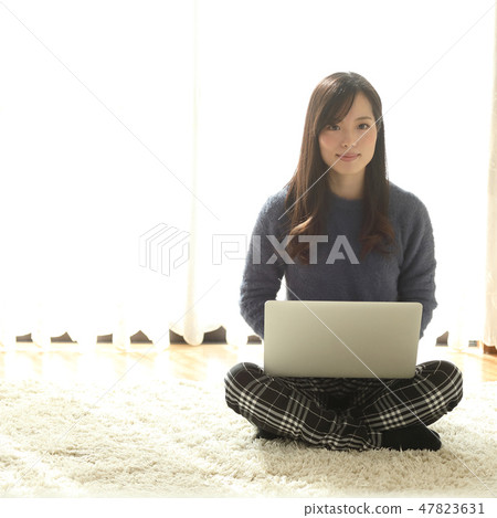 A woman who plays a personal computer A woman who plays a personal computer 47823631