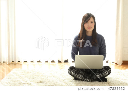 A woman who plays a personal computer A woman who plays a personal computer 47823632