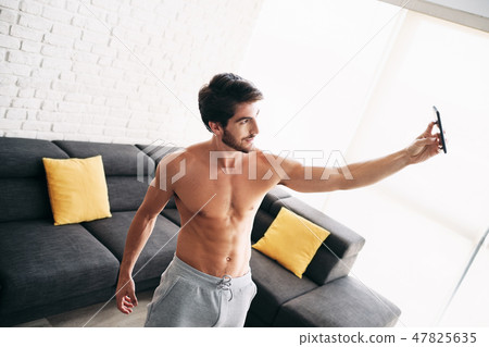 Man Working Out At Home Taking Selfie Picture With Phone Man Working Out At Home Taking Selfie Picture With Phone 47825635