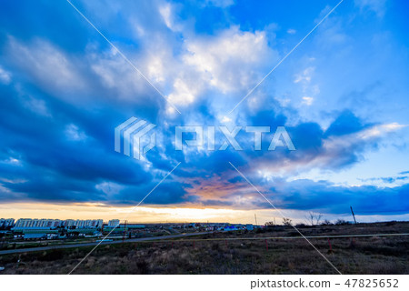 Distant view of city and dramatic skyscape with clouds 47825652