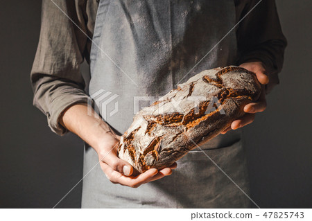 Baker or chef holding fresh made bread 47825743