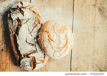 Tasty fresh bread on wooden table 47826307