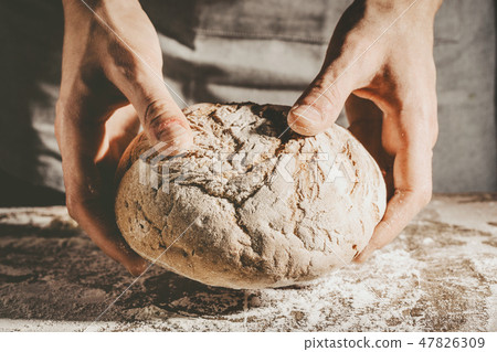 Baker or chef holding fresh made bread Baker or chef holding fresh made bread 47826309