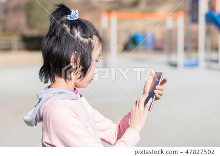 Elementary school student using a smartphone Elementary school student using a smartphone 47827502