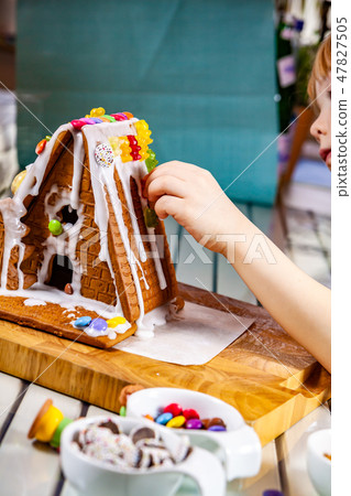 Familiy building a sweet ginger bread house Familiy building a sweet ginger bread house 47827505