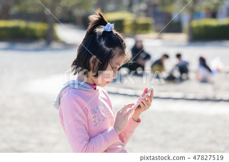Elementary school student using a smartphone Elementary school student using a smartphone 47827519