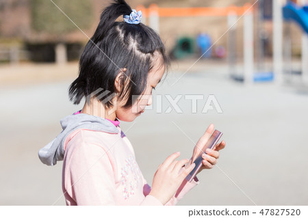 Elementary school student using a smartphone Elementary school student using a smartphone 47827520