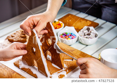 Familiy building a sweet ginger bread house 47827528