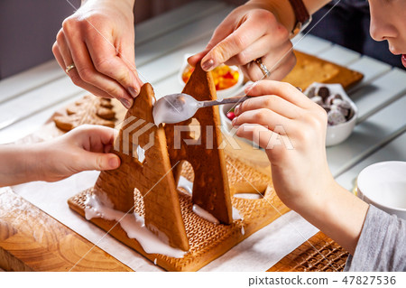 Familiy building a sweet ginger bread house Familiy building a sweet ginger bread house 47827536