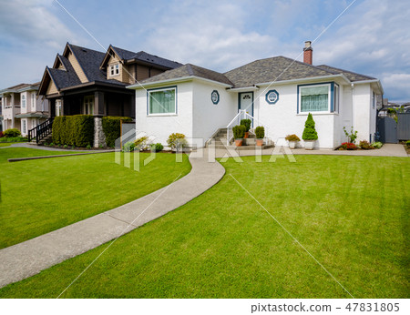 Main entrance of family house with concrete pathway over the yard on cloudy day Main entrance of family house with concrete pathway over the yard on cloudy day 47831805
