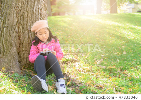 Asian cute girl using mobile phone in park, Asian cute girl using mobile phone in park, 47833046