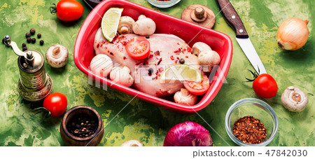 Raw chicken in baking dish 47842030