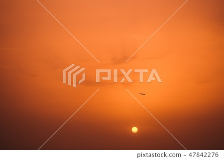 Dark silhouette of airplane in distance in air Dark silhouette of airplane in distance in air 47842276