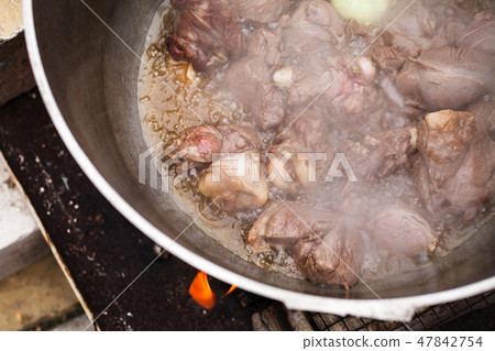 Lamb with onion boiling in a cauldron Lamb with onion boiling in a cauldron 47842754