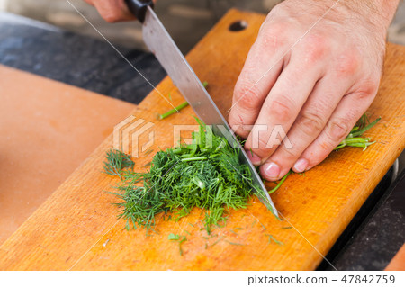 Greens chopping. Male hand with knife Greens chopping. Male hand with knife 47842759