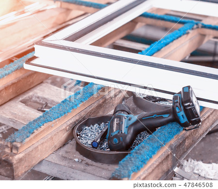 Production of pvc windows, screwdriver lies near the pvc frame, manufacturing of plastic windows Production of pvc windows, screwdriver lies near the pvc frame, manufacturing of plastic windows 47846508