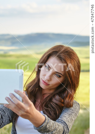Beautiful brunette woman  photographing selfie on a tablet on Tu 47847746