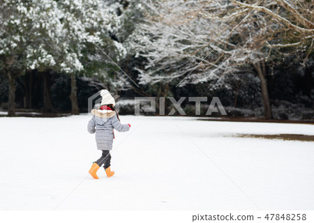 A girl playing in a snowy park 47848258