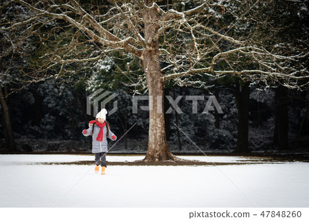 A girl playing in a snowy park 47848260