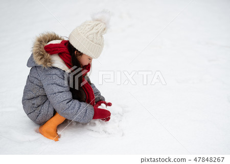 A girl playing in a snowy park 47848267