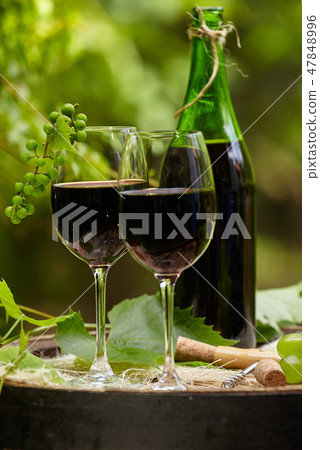 Red wine bottle and wine glass on wodden barrel. Red wine bottle and wine glass on wodden barrel. 47848996