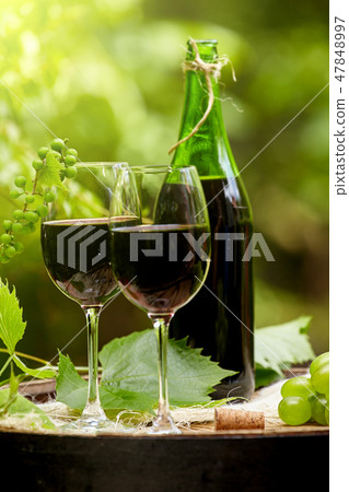 Red wine bottle and wine glass on wodden barrel. Red wine bottle and wine glass on wodden barrel. 47848997