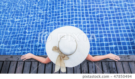 Woman in hat relaxing at the pool Woman in hat relaxing at the pool 47850494