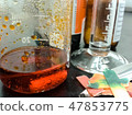 Orange chemical reaction inside a glass beaker 47853775